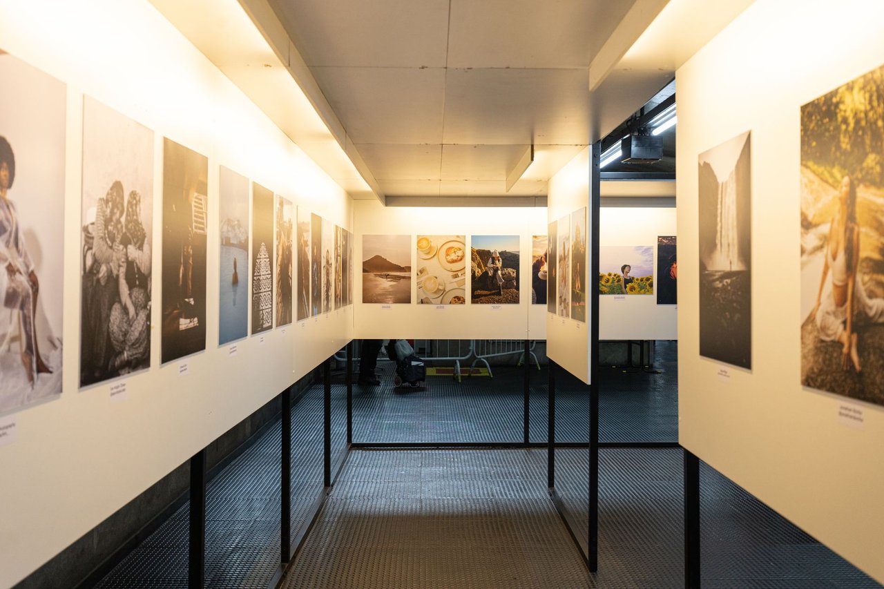 Galeria moderna iluminada com fotografias expostas em painéis nas paredes.
