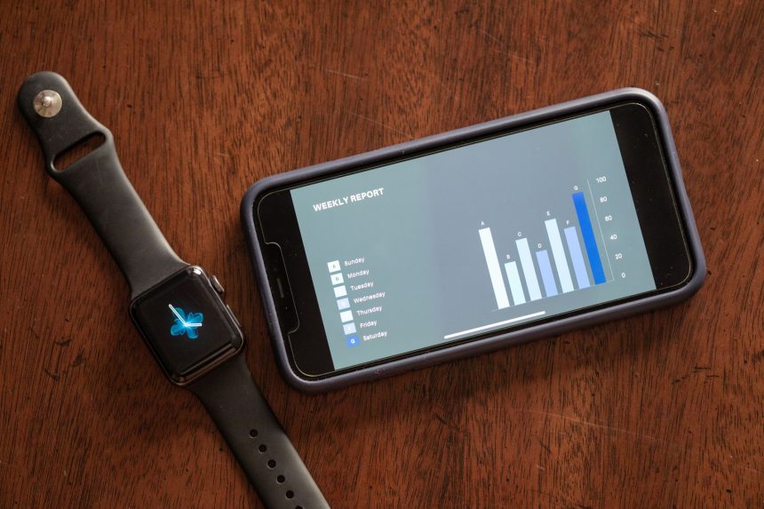 Smartphone e smartwatch exibem um relatório semanal de saúde sobre uma mesa de madeira.